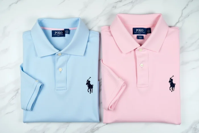 Comparaison côte à côte d'un polo Ralph Lauren et d'un polo Polo Club posés à plat sur marbre blanc pour distinguer les logos